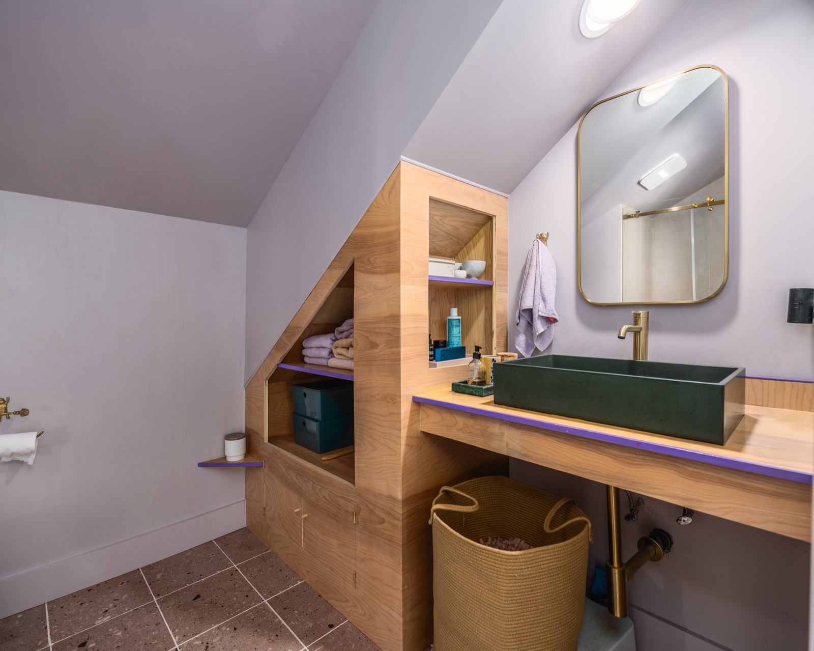 Custom 2025 primary en-suite bath with integrated wood storage and a green vessel sink.